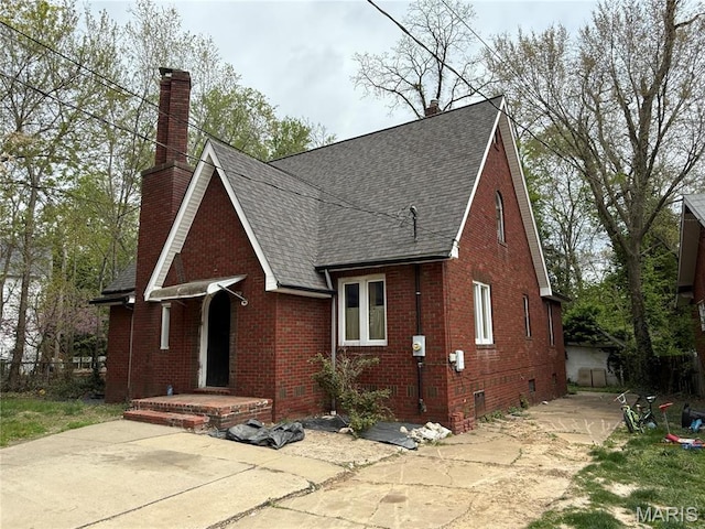 1548 Highland Ave, Alton, IL 62002 - view of front of home featuring roof with shingles, brick siding, a chimney, and concrete driveway