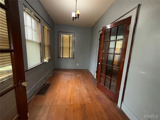 1548 Highland Ave, Alton, IL 62002 - spare room with wood finished floors, a chandelier, and baseboards