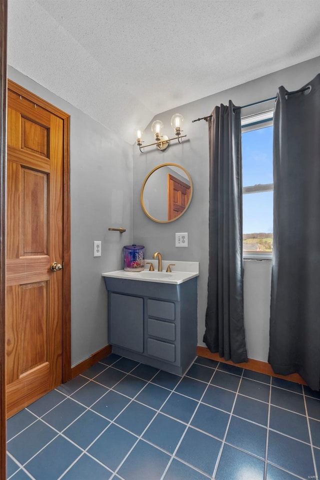 7238 State Highway D, Jackson, MO 63755 - bathroom with vaulted ceiling, a textured ceiling, tile patterned flooring, vanity, and baseboards