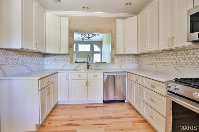 409 Country Club Vw, Edwardsville, IL 62025 - kitchen featuring stainless steel appliances, a sink, light stone counters, light wood-style floors, and crown molding