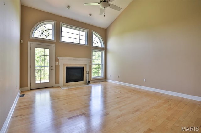 409 Country Club Vw, Edwardsville, IL 62025 - unfurnished living room featuring high vaulted ceiling, light wood finished floors, ceiling fan, baseboards, and a fireplace with flush hearth
