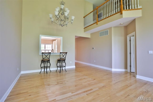 409 Country Club Vw, Edwardsville, IL 62025 - dining area with a chandelier, wood finished floors, a high ceiling, and baseboards