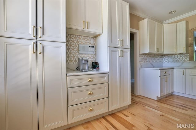 409 Country Club Vw, Edwardsville, IL 62025 - kitchen featuring light countertops, tasteful backsplash, light wood-style floors, crown molding, and white cabinets