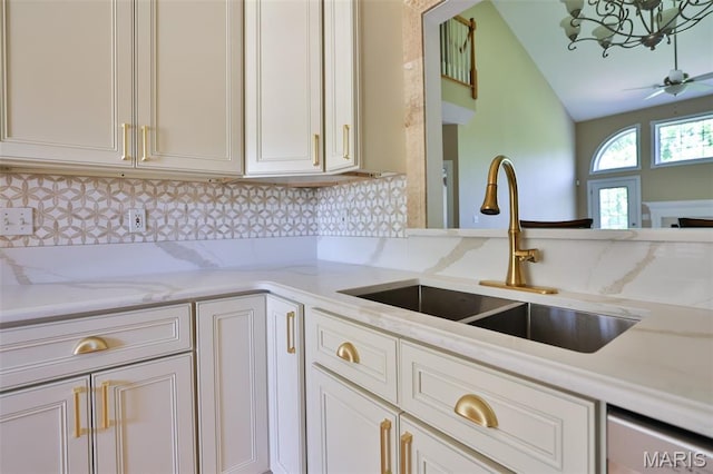 409 Country Club Vw, Edwardsville, IL 62025 - kitchen featuring a sink, decorative backsplash, light stone countertops, lofted ceiling, and a chandelier