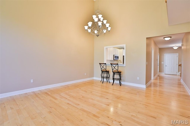 409 Country Club Vw, Edwardsville, IL 62025 - dining space featuring a chandelier, light wood-type flooring, baseboards, and a high ceiling