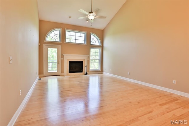 409 Country Club Vw, Edwardsville, IL 62025 - unfurnished living room featuring light wood-style flooring, high vaulted ceiling, healthy amount of natural light, ceiling fan, and baseboards