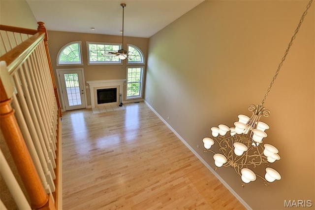 409 Country Club Vw, Edwardsville, IL 62025 - unfurnished living room with ceiling fan, light wood-style flooring, a chandelier, and a fireplace