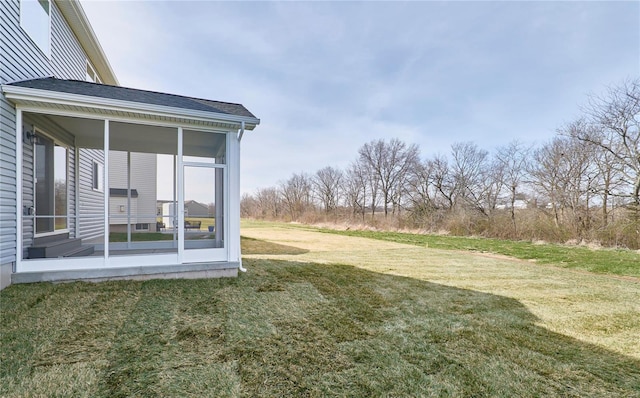 view of grassy yard with a sunroom