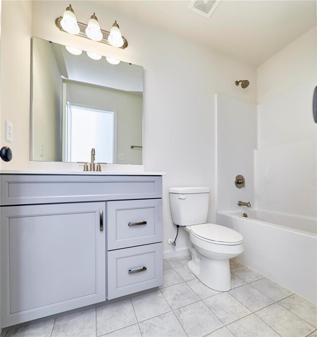 full bath featuring tile patterned floors, toilet, vanity, tub / shower combination, and baseboards