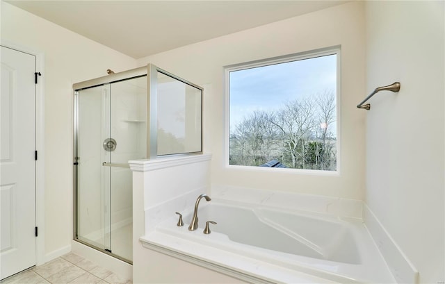bathroom with a stall shower, a bath, and tile patterned floors