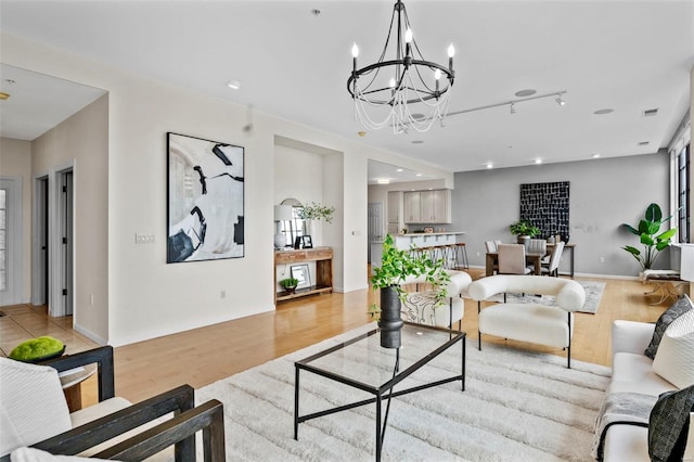 living room featuring light wood-type flooring, a chandelier, and recessed lighting