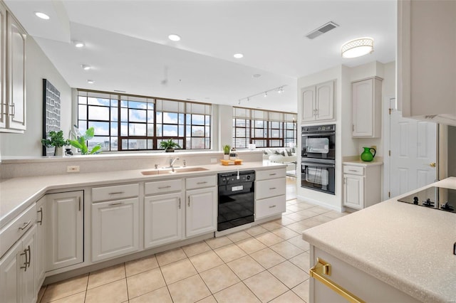 kitchen with black appliances, a sink, light tile patterned floors, light countertops, and recessed lighting