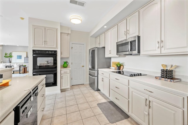 kitchen featuring black appliances, light countertops, and light tile patterned floors