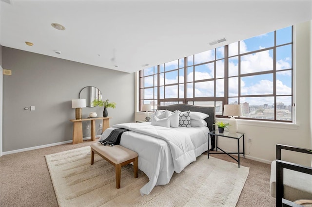 bedroom featuring light carpet and baseboards