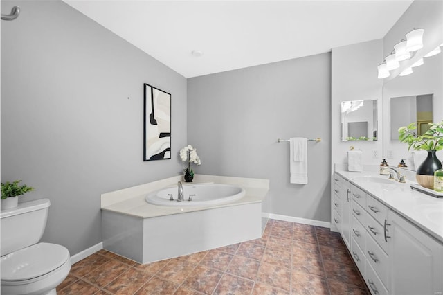 bathroom with toilet, baseboards, a garden tub, and vanity