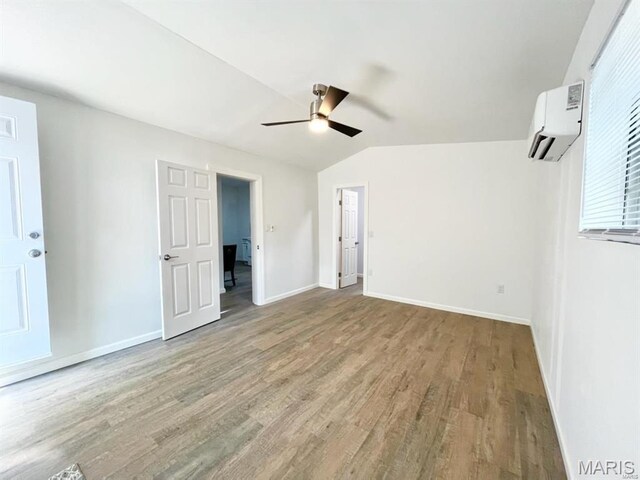 360 3rd St, Ellington, MO 63638 - unfurnished bedroom with an AC wall unit, wood finished floors, baseboards, lofted ceiling, and a ceiling fan