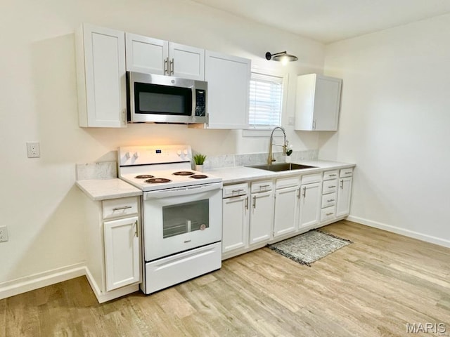 360 3rd St, Ellington, MO 63638 - kitchen featuring electric stove, stainless steel microwave, a sink, light wood-style flooring, and light countertops