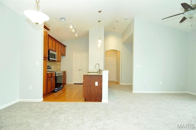 39 Kassebaum Ln Unit 303, Saint Louis, MO 63129 - kitchen with appliances with stainless steel finishes, light colored carpet, open floor plan, ceiling fan, and arched walkways