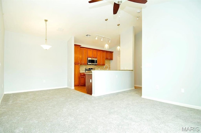 39 Kassebaum Ln Unit 303, Saint Louis, MO 63129 - kitchen with stainless steel microwave, light colored carpet, a ceiling fan, open floor plan, and tasteful backsplash