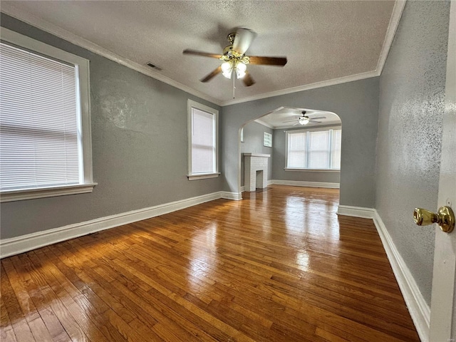 5056 Lindenwood Ave, Saint Louis, MO 63109 - unfurnished living room with a textured wall, hardwood / wood-style floors, arched walkways, ceiling fan, and a textured ceiling
