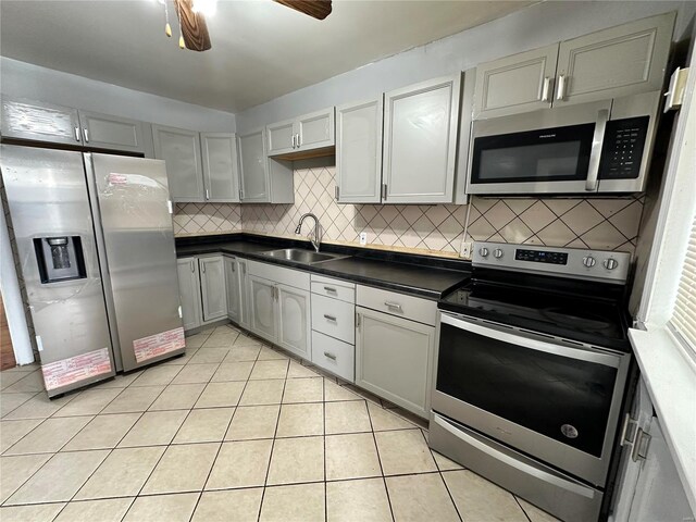 5056 Lindenwood Ave, Saint Louis, MO 63109 - kitchen featuring stainless steel appliances, a sink, dark countertops, and tasteful backsplash
