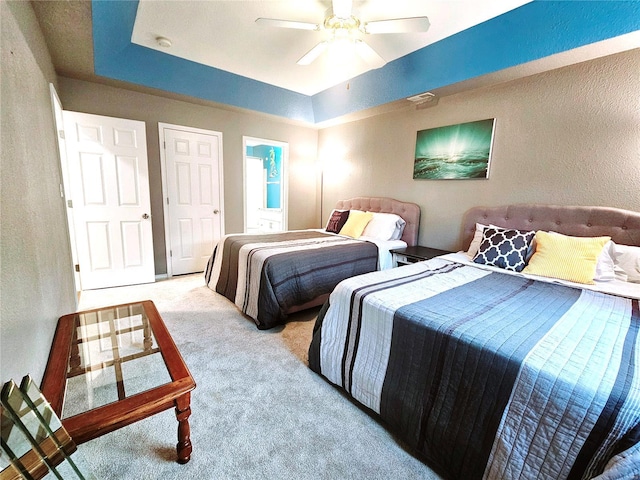 86 Aqua Fin Rd Unit 3B, Osage Beach, MO 65049 - carpeted bedroom featuring a textured wall, a ceiling fan, and a tray ceiling