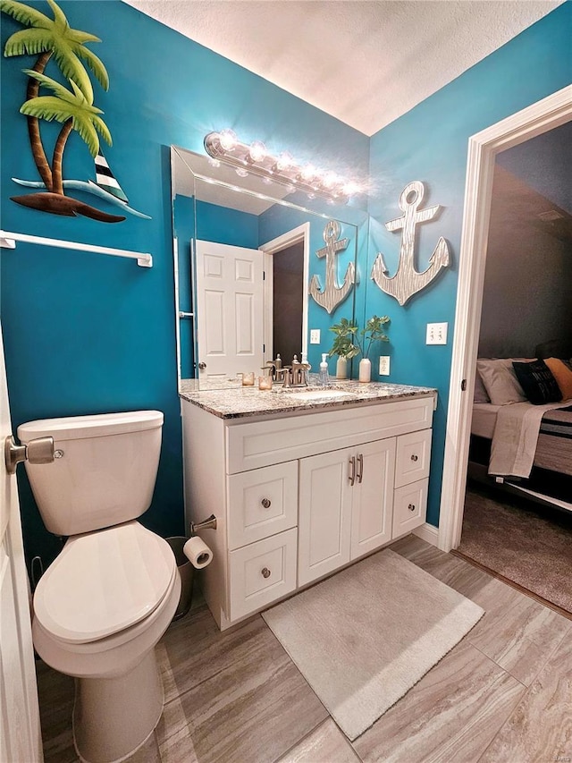 86 Aqua Fin Rd Unit 3B, Osage Beach, MO 65049 - bathroom with wood finished floors, toilet, vanity, and ensuite bath