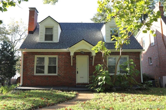 7710 Saint Albans Ave, Maplewood, MO 63117 - new england style home featuring brick siding, a chimney, and a shingled roof