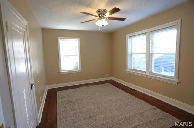 7710 Saint Albans Ave, Maplewood, MO 63117 - unfurnished room featuring dark wood-style flooring, baseboards, ceiling fan, and a textured ceiling