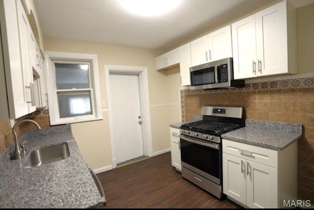 7710 Saint Albans Ave, Maplewood, MO 63117 - kitchen with stainless steel appliances, a sink, white cabinets, dark wood-type flooring, and tasteful backsplash