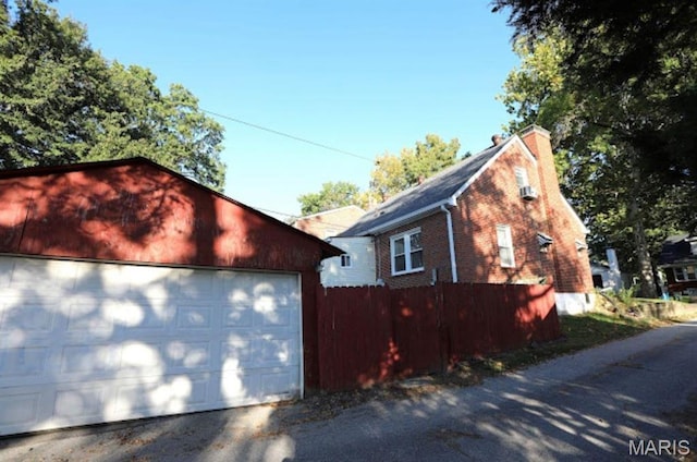 7710 Saint Albans Ave, Maplewood, MO 63117 - view of side of property featuring an outdoor structure, brick siding, a garage, and a chimney