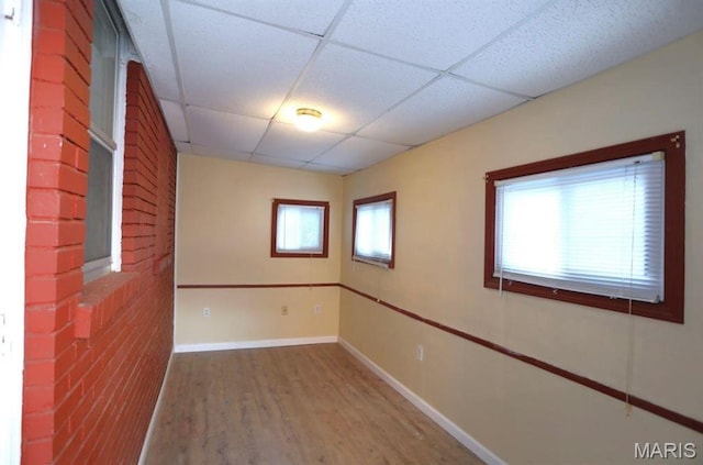 7710 Saint Albans Ave, Maplewood, MO 63117 - empty room with a drop ceiling, wood finished floors, and baseboards