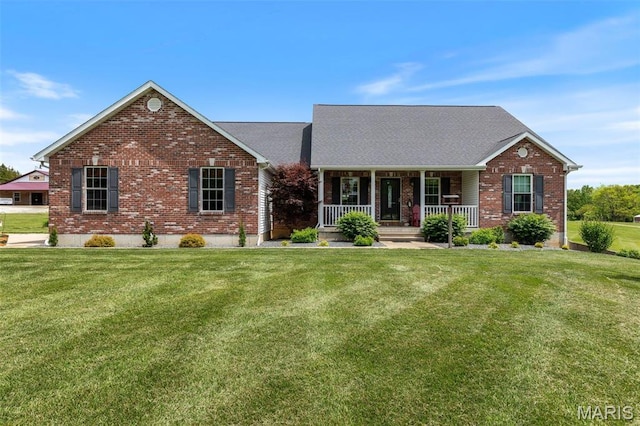 view of front of property with brick siding, a porch, and a front yard