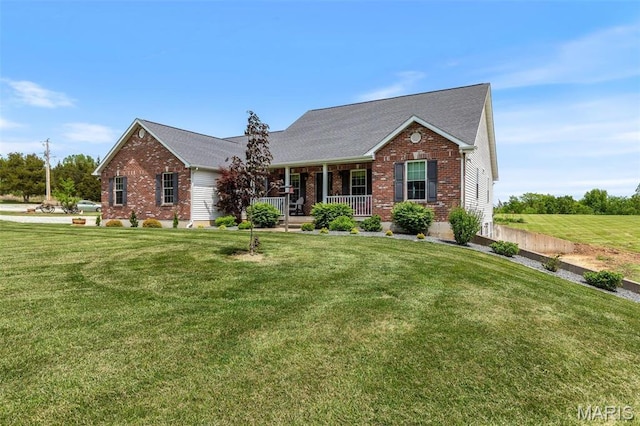 view of front of home featuring covered porch, brick siding, and a front lawn