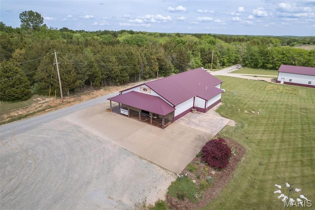 aerial view of property and surrounding area with a heavily wooded area