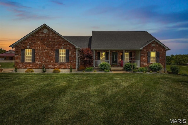 view of front of house with brick siding, a porch, and a front yard