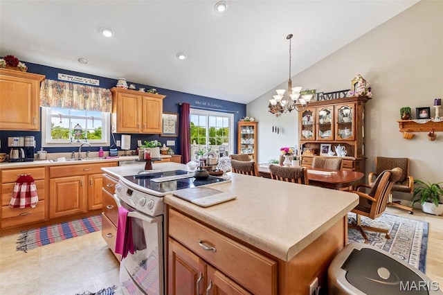 kitchen featuring electric stove, a sink, plenty of natural light, a center island, and lofted ceiling