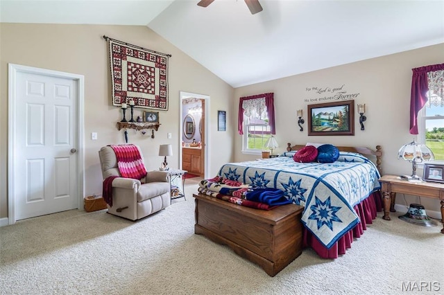 bedroom with vaulted ceiling, carpet floors, multiple windows, and ensuite bath