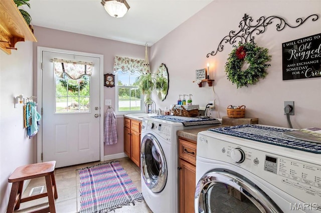 laundry area featuring cabinet space, independent washer and dryer, and light tile patterned floors