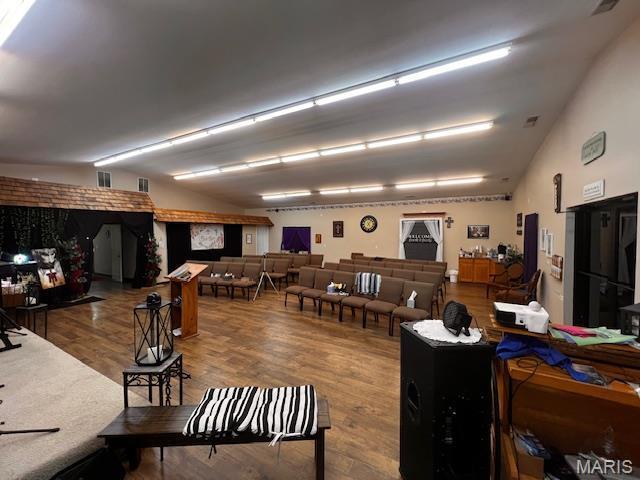 miscellaneous room featuring lofted ceiling and wood finished floors