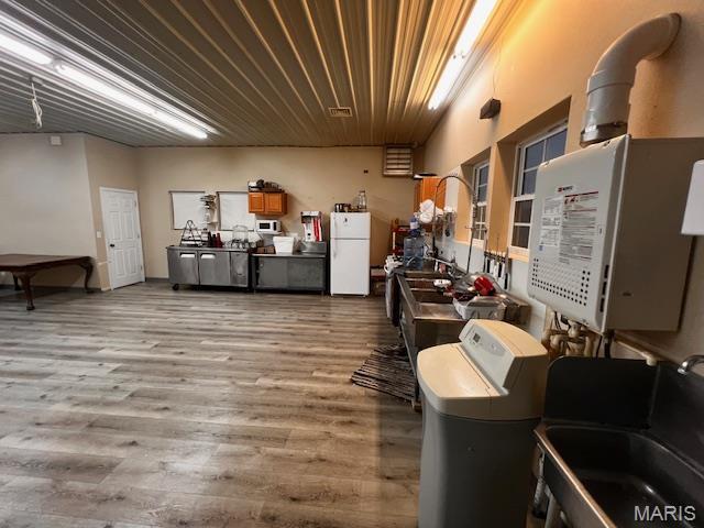 below grade area featuring freestanding refrigerator, a sink, wood finished floors, and wooden ceiling