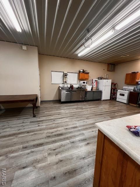 basement with freestanding refrigerator and light wood-style floors