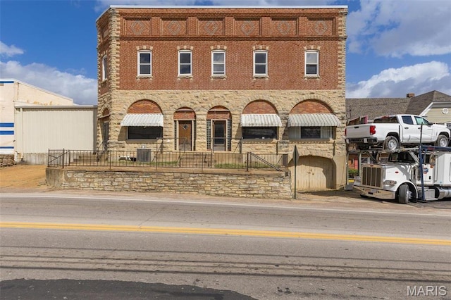 702 Benham St, Bonne Terre, MO 63628 - view of front facade with cooling unit, brick siding, and covered porch