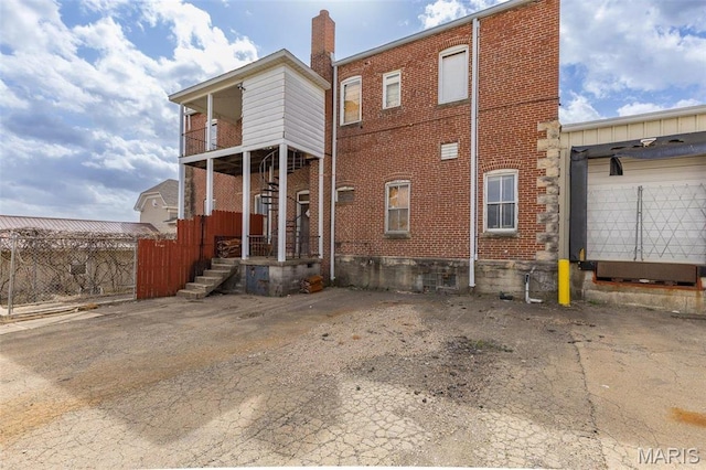 702 Benham St, Bonne Terre, MO 63628 - rear view of house with brick siding, a chimney, and stairs