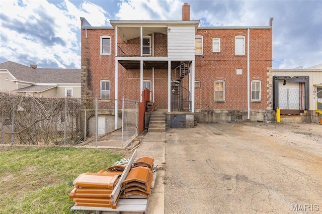 702 Benham St, Bonne Terre, MO 63628 - back of property with fence, brick siding, stairs, and a chimney