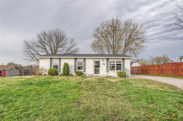 ranch-style house with brick siding and gravel driveway