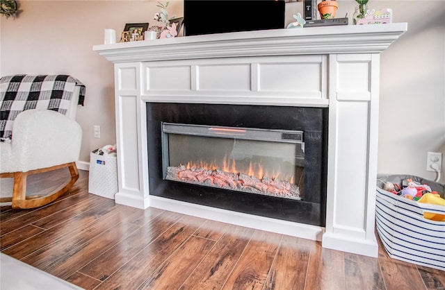 detailed view of a warm lit fireplace and wood finished floors