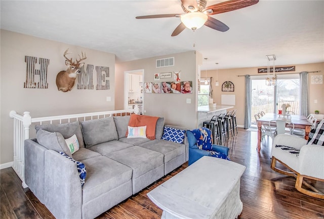 living room with dark wood finished floors, a ceiling fan, healthy amount of natural light, and baseboards