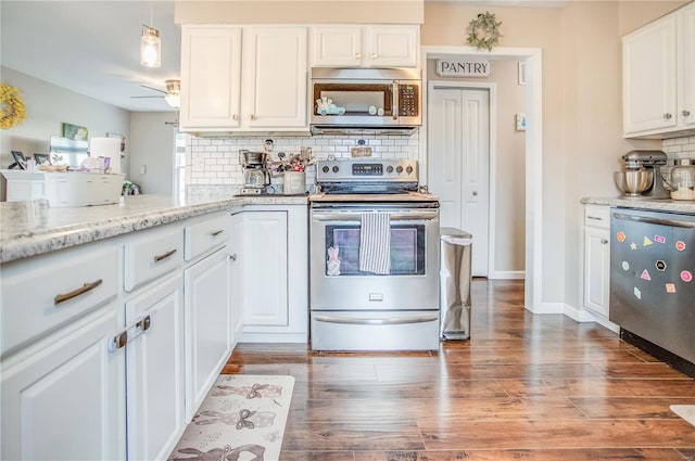 kitchen with stainless steel appliances, tasteful backsplash, wood finished floors, white cabinets, and light stone counters