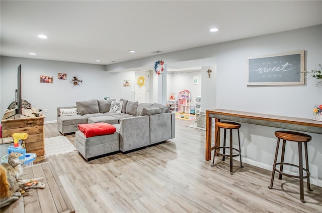living area with light wood-type flooring, recessed lighting, and baseboards